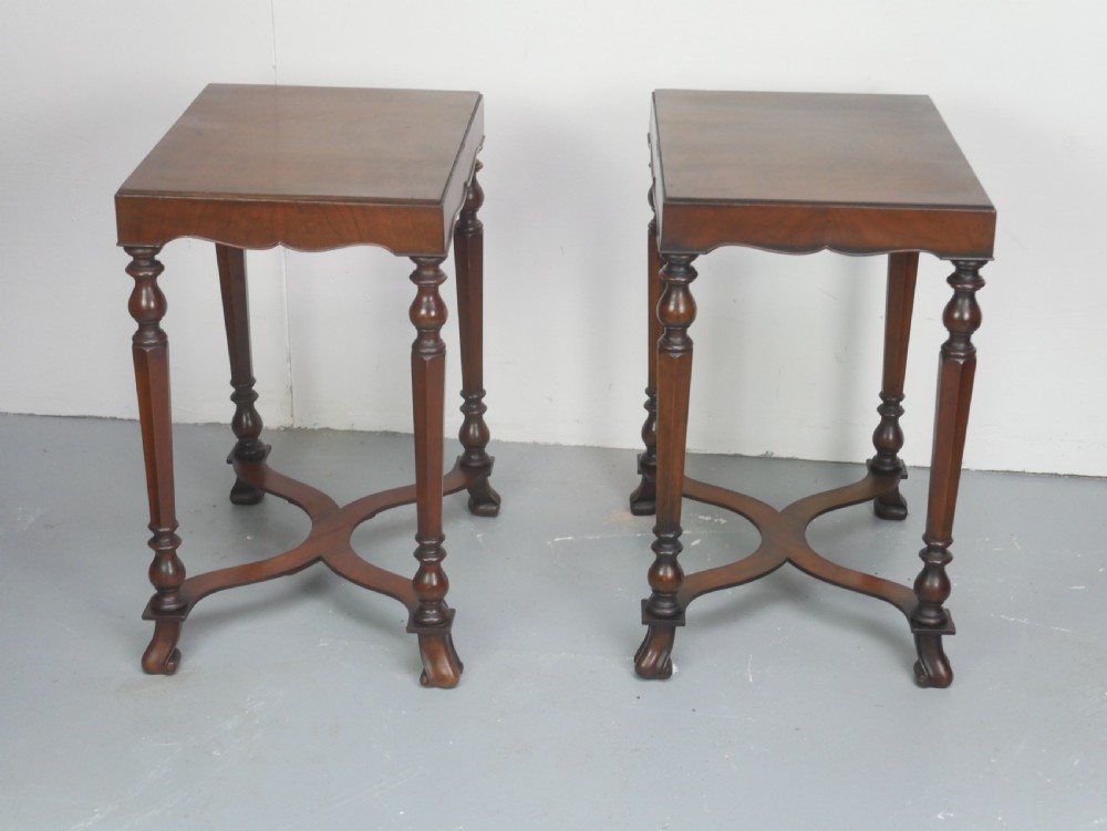 A matching pair of polished warm brown mahogany side tables featuring raised tray-top edges, turned legs, and curved X-stretchers. View XIV