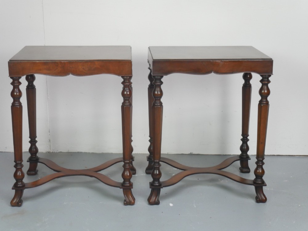 A matching pair of polished warm brown mahogany side tables featuring raised tray-top edges, turned legs, and curved X-stretchers. View XV