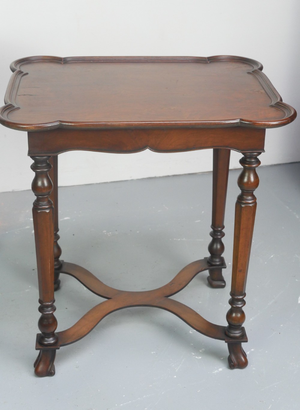 A matching pair of polished warm brown mahogany side tables featuring raised tray-top edges, turned legs, and curved X-stretchers. View XVII