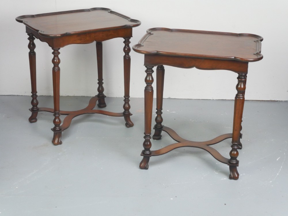 A matching pair of polished warm brown mahogany side tables featuring raised tray-top edges, turned legs, and curved X-stretchers. View XVIII