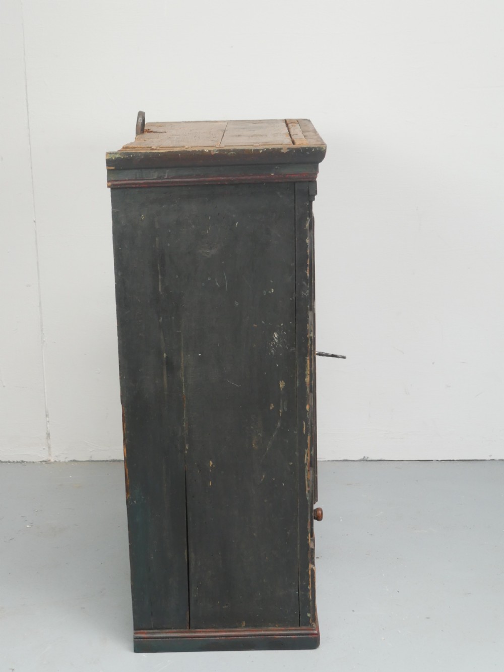 An antique dark green Swedish wall cupboard featuring hand-painted floral motifs, a central panel door, and a single lower drawer. View V