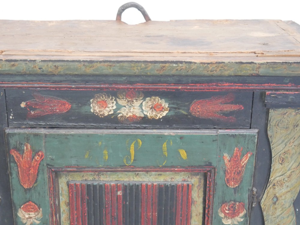 An antique dark green Swedish wall cupboard featuring hand-painted floral motifs, a central panel door, and a single lower drawer. View IX