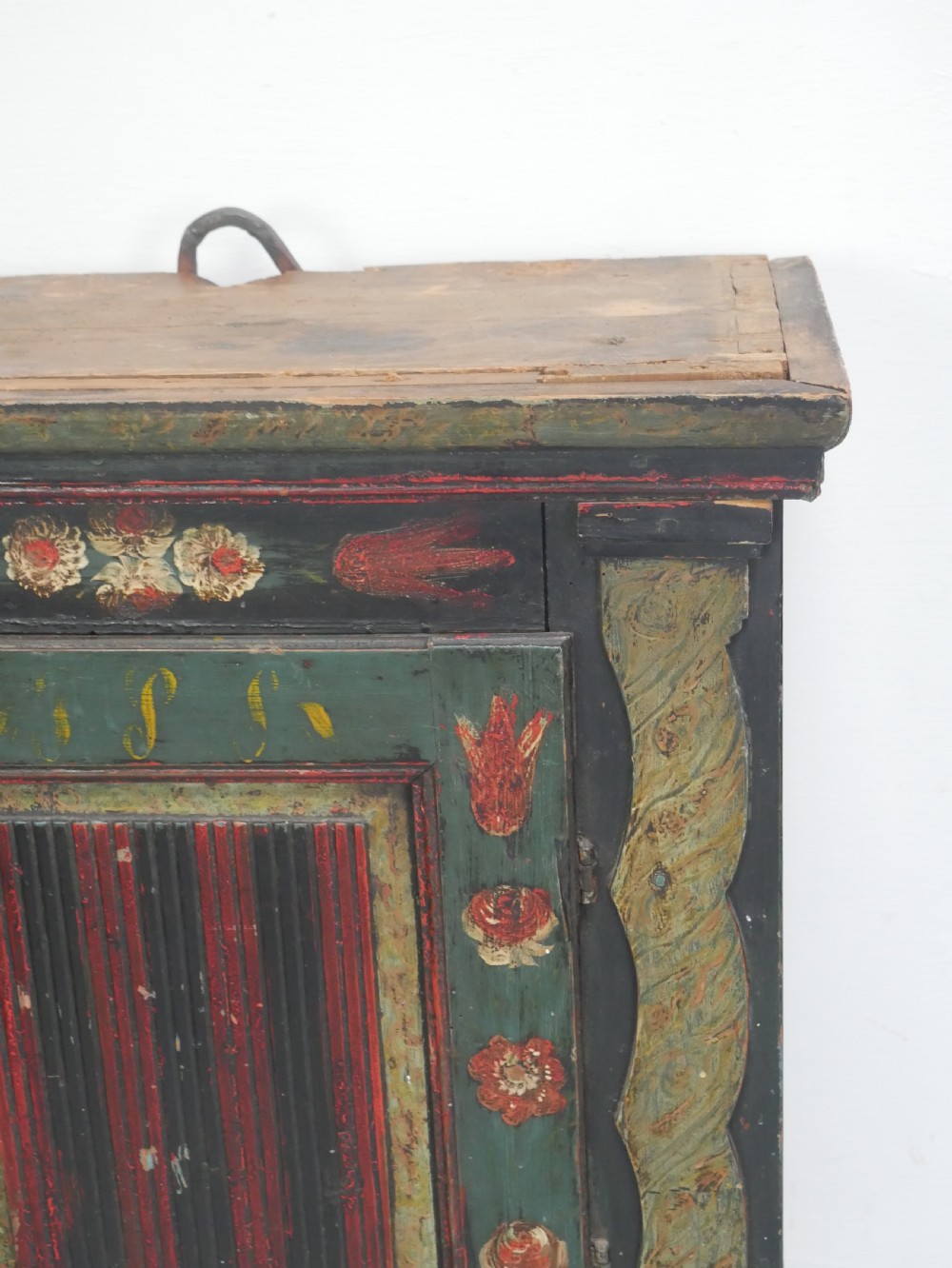 An antique dark green Swedish wall cupboard featuring hand-painted floral motifs, a central panel door, and a single lower drawer. View XI