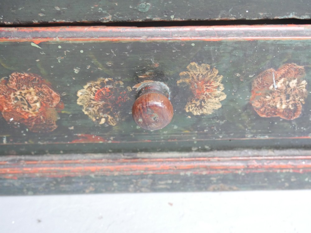 An antique dark green Swedish wall cupboard featuring hand-painted floral motifs, a central panel door, and a single lower drawer. View XIII