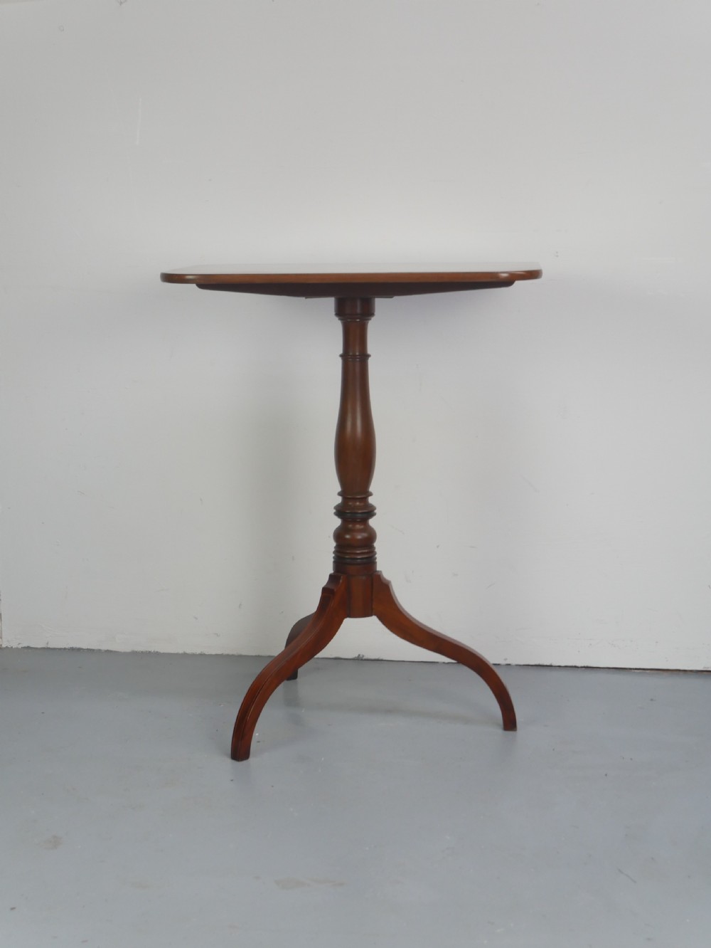 An antique mahogany tilt-top table with a rectangular inlaid tabletop raised vertically on a turned central pedestal and three curved legs. View III