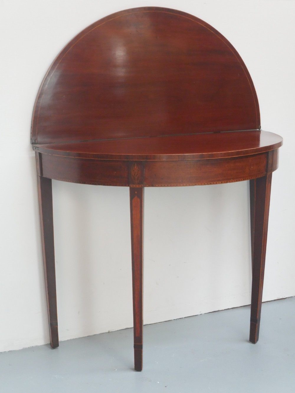 A Scottish Georgian mahogany demi-lune fold-over side table with inlaid square tapered legs. View V