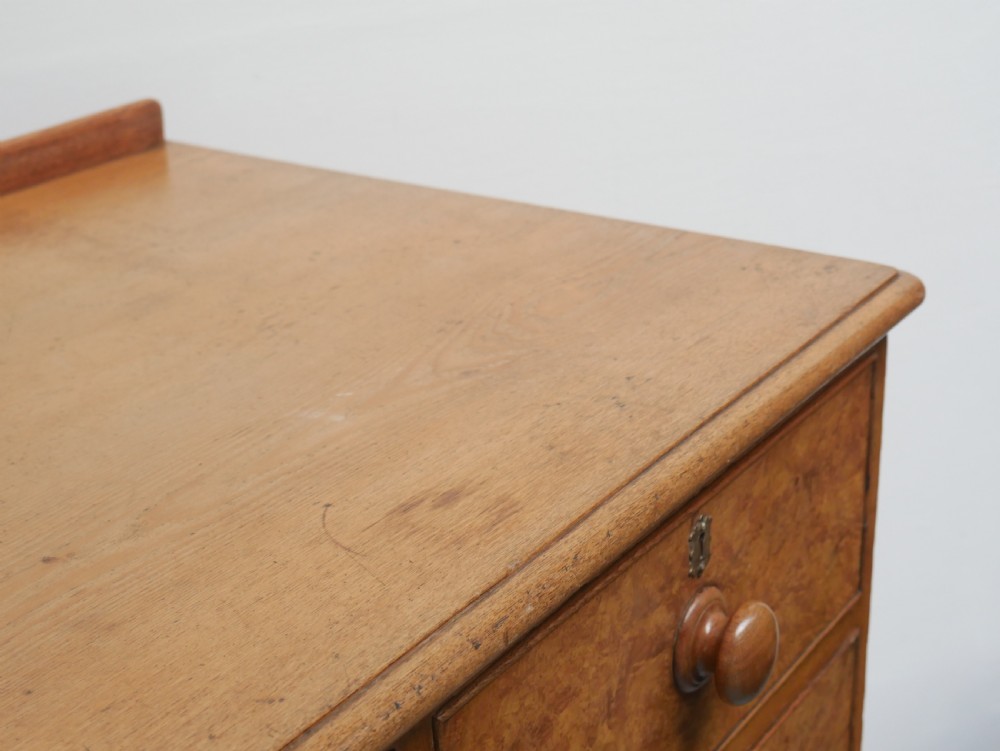 An antique burr ash chest of drawers featuring two short over three long graduated drawers with turned wooden knobs and bracket feet. View VII