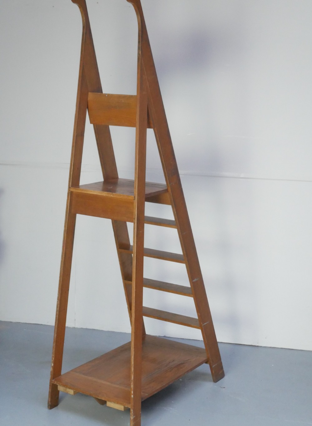 A tall freestanding oak library step ladder featuring multiple wide treads, shaped handholds at the top, and a warm natural wood finish. View VIII