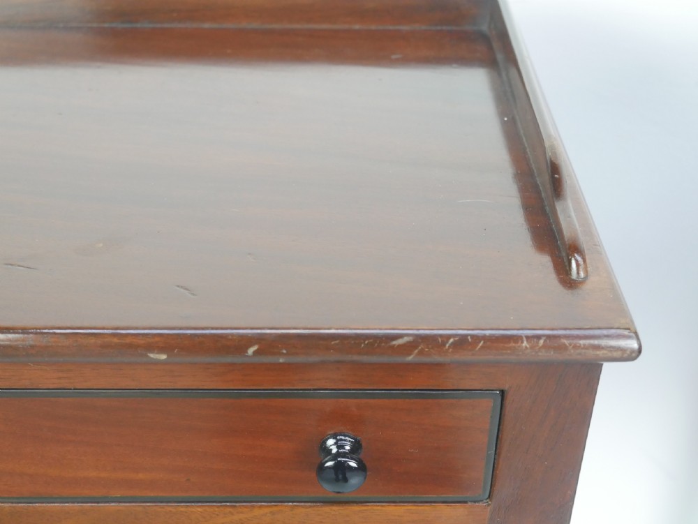 A pair of tall slim dark mahogany bedside tables featuring tray tops, two drawers with black knobs, turned legs, and curved X-frame stretchers. View II