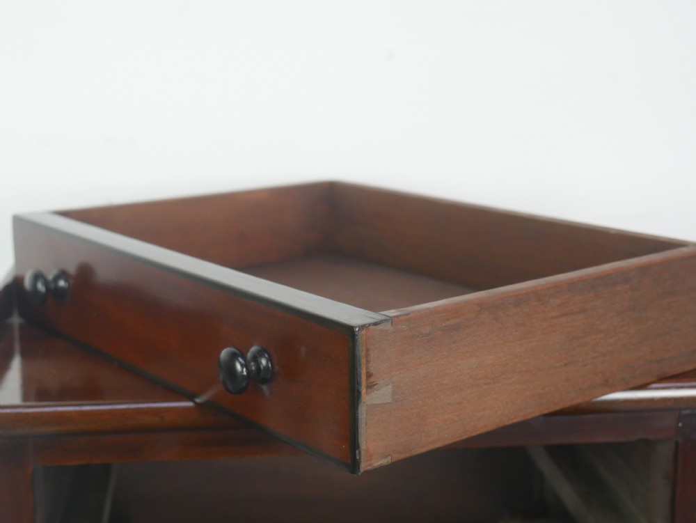 A pair of tall slim dark mahogany bedside tables featuring tray tops, two drawers with black knobs, turned legs, and curved X-frame stretchers. View III