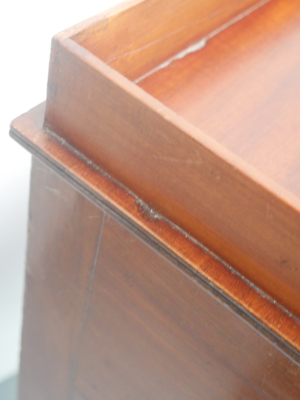 A Regency mahogany bedside cupboard featuring a reeded tambour door, fine boxwood stringing inlay, a raised tray top gallery, and slender turned legs. View IV