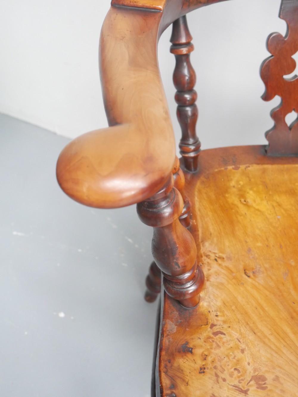 A 19th-century yewwood Windsor armchair featuring a high hoop back, central pierced fretwork splat, turned spindles, and a shaped wooden seat. View II