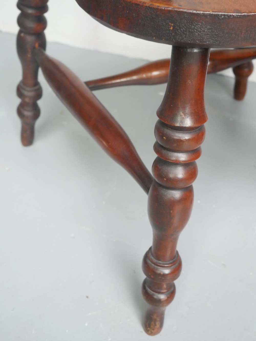 A 19th-century yewwood Windsor armchair featuring a high hoop back, central pierced fretwork splat, turned spindles, and a shaped wooden seat. View VII