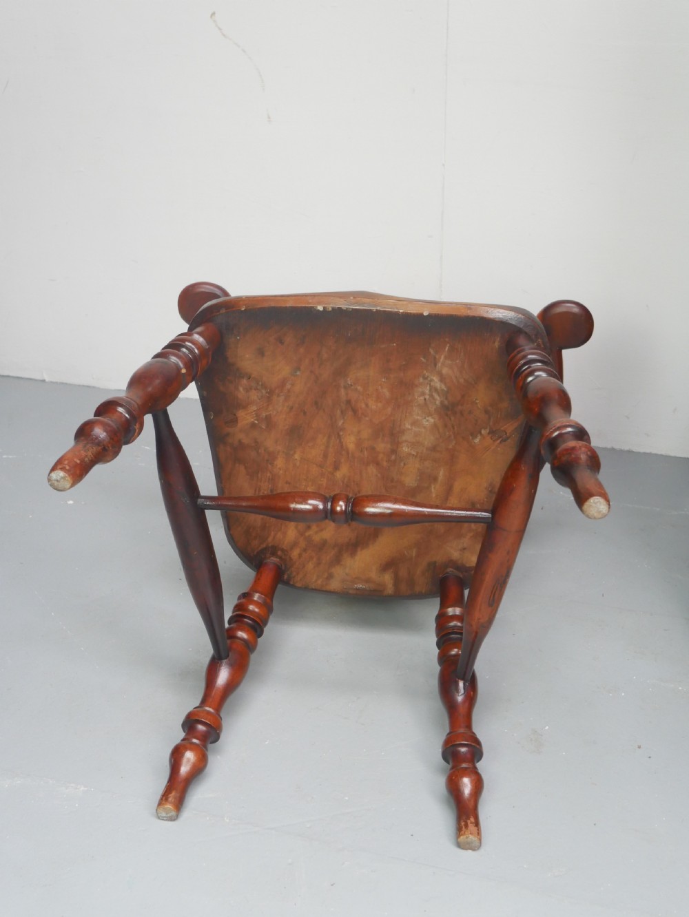 A 19th-century yewwood Windsor armchair featuring a high hoop back, central pierced fretwork splat, turned spindles, and a shaped wooden seat. View X