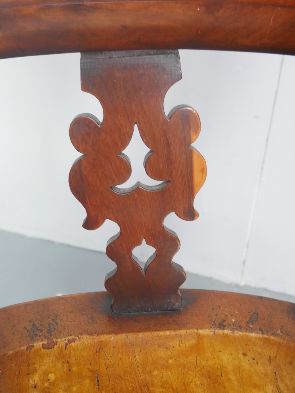 A 19th-century yewwood Windsor armchair featuring a high hoop back, central pierced fretwork splat, turned spindles, and a shaped wooden seat. View XI