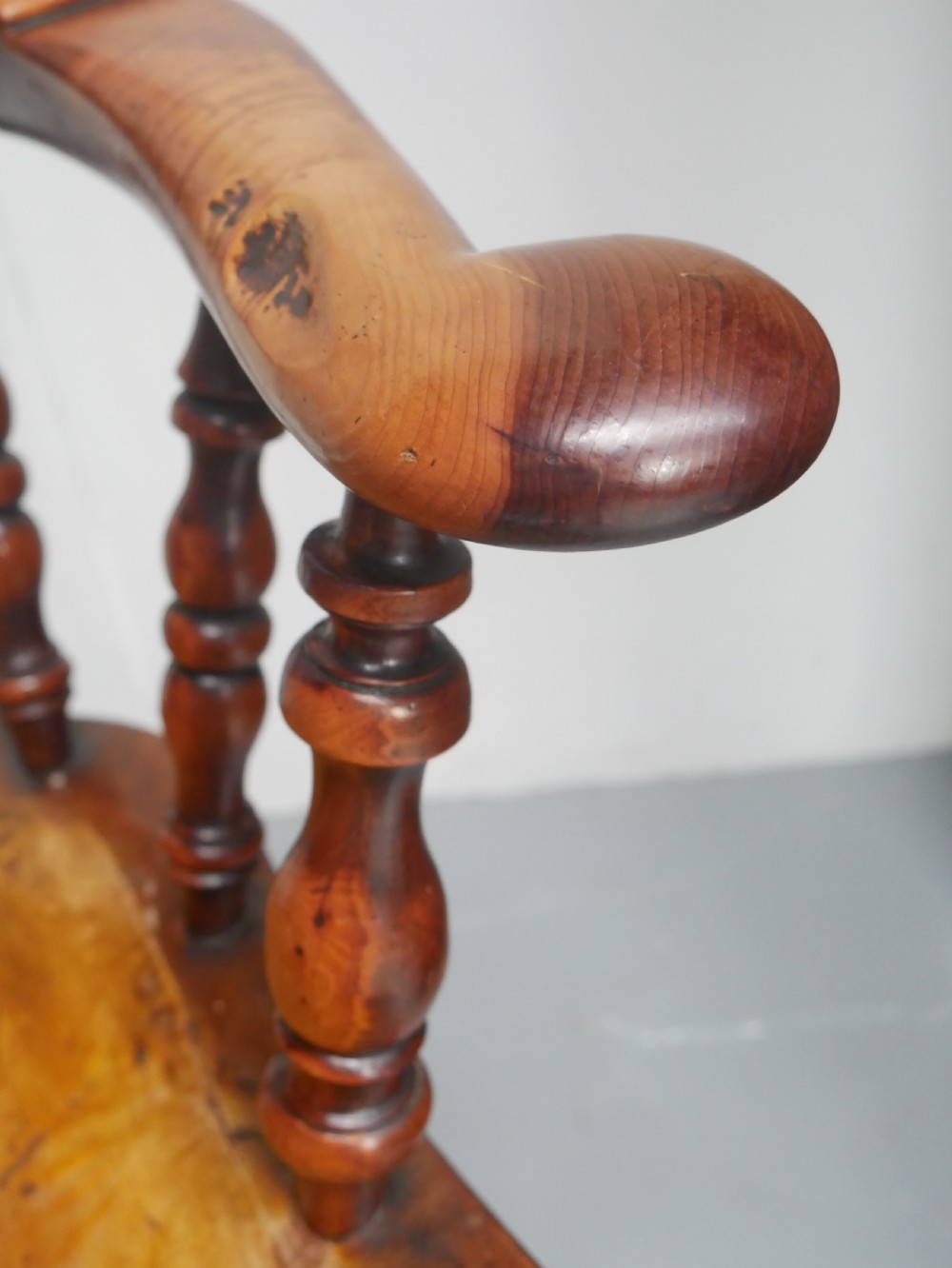 A 19th-century yewwood Windsor armchair featuring a high hoop back, central pierced fretwork splat, turned spindles, and a shaped wooden seat. View XII