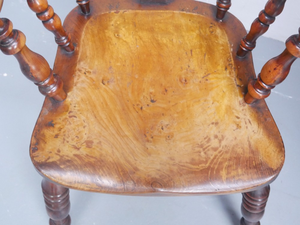 A 19th-century yewwood Windsor armchair featuring a high hoop back, central pierced fretwork splat, turned spindles, and a shaped wooden seat. View XIII