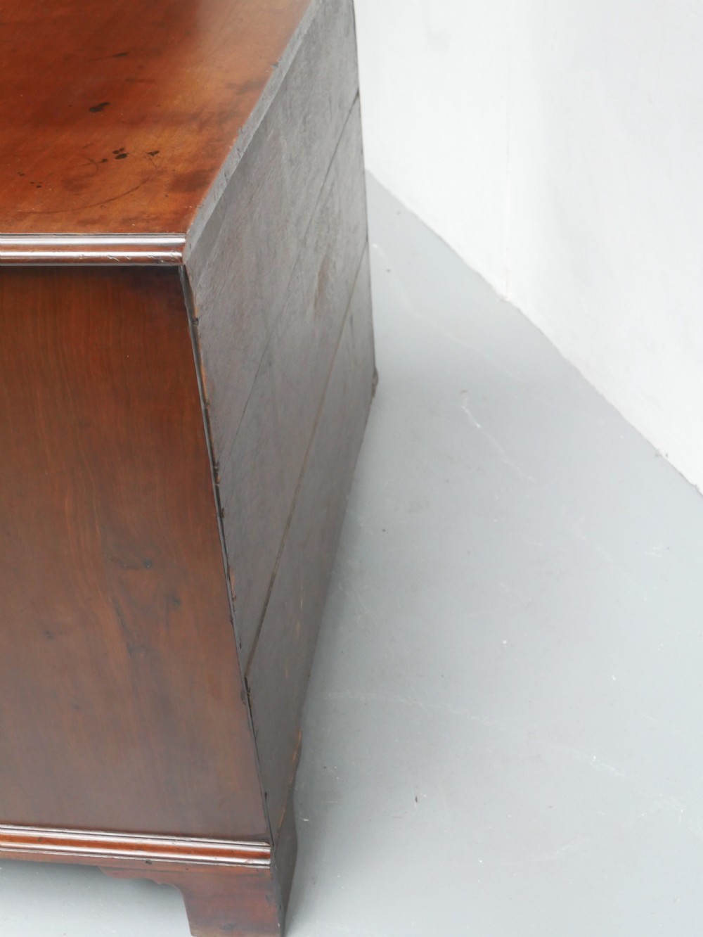 An eighteenth-century Georgian serpentine-fronted mahogany chest of drawers featuring brass swan-neck handles and bracket feet. View VII