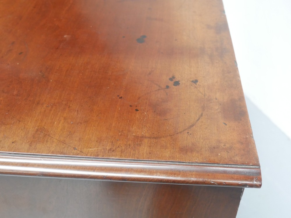 An eighteenth-century Georgian serpentine-fronted mahogany chest of drawers featuring brass swan-neck handles and bracket feet. View VIII