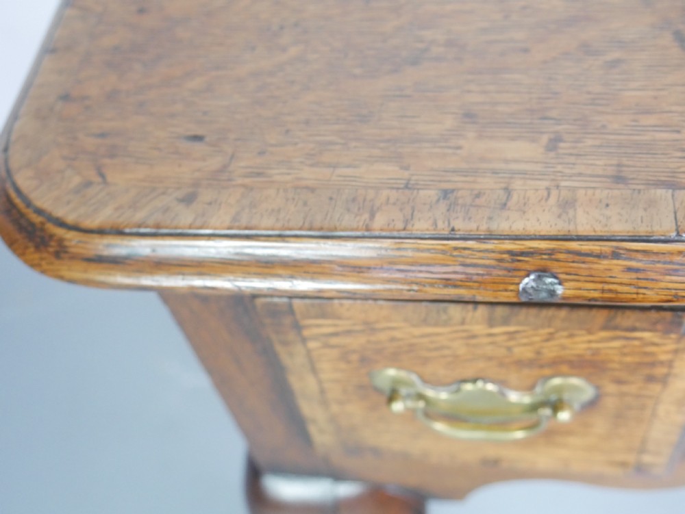 An eighteenth-century Georgian oak lowboy table featuring three drawers with brass handles, a shaped apron, and four cabriole legs ending in pad feet. View VI
