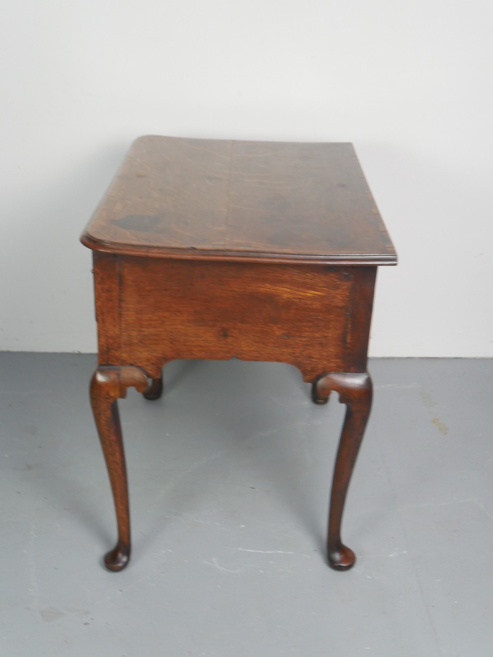 An eighteenth-century Georgian oak lowboy table featuring three drawers with brass handles, a shaped apron, and four cabriole legs ending in pad feet. View IX