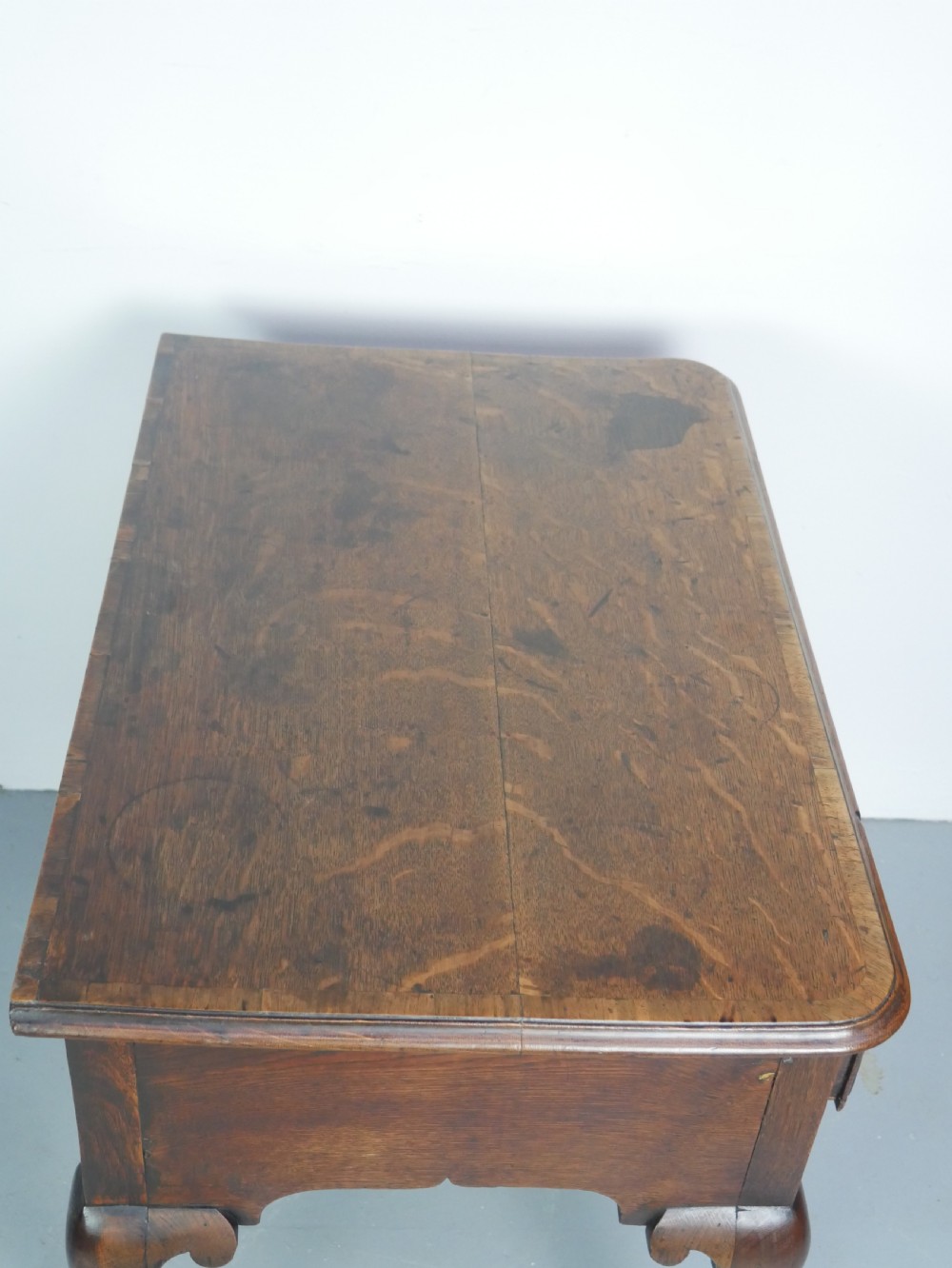 An eighteenth-century Georgian oak lowboy table featuring three drawers with brass handles, a shaped apron, and four cabriole legs ending in pad feet. View XII