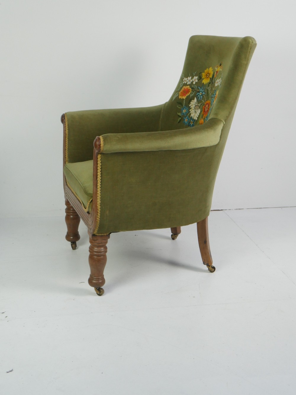 A Regency period style armchair upholstered in olive green velvet with floral needlepoint embroidery on the backrest and seat cushion. View IV