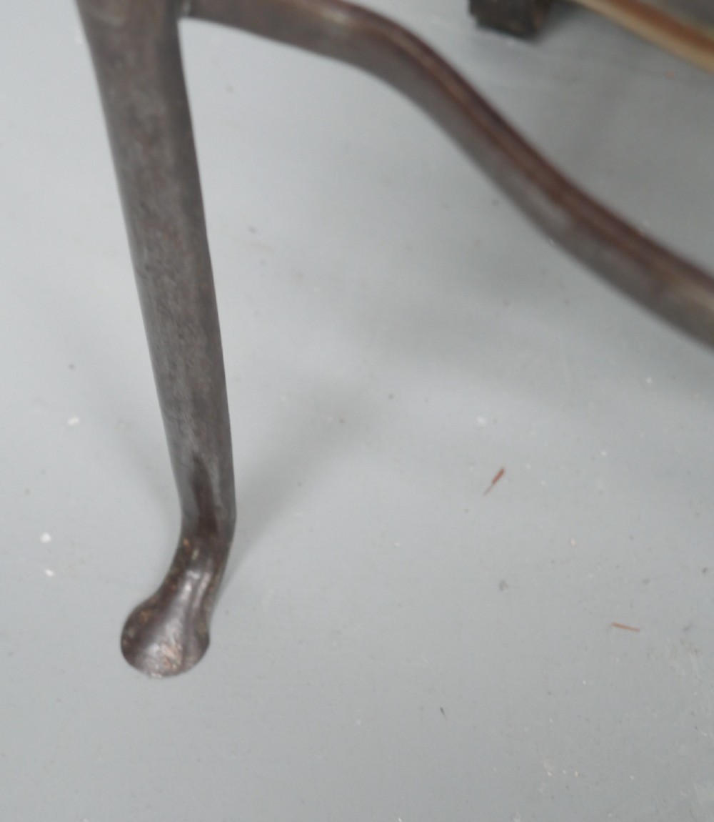 A small Georgian brass and steel footman featuring a top handle slot, side ring handles, and a pierced decorative front apron raised on shaped legs. View VI