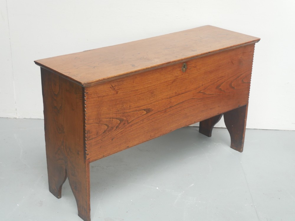 An antique timber six-plank coffer crafted from warm brown elm featuring a central brass keyhole escutcheon and shaped bootjack side panels. View II
