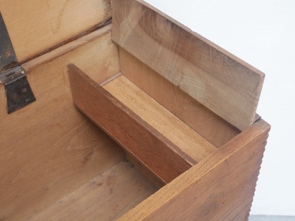 An antique timber six-plank coffer crafted from warm brown elm featuring a central brass keyhole escutcheon and shaped bootjack side panels. View IV