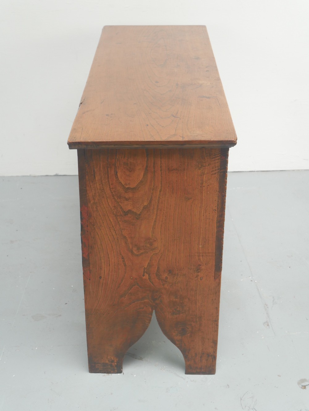 An antique timber six-plank coffer crafted from warm brown elm featuring a central brass keyhole escutcheon and shaped bootjack side panels. View VI