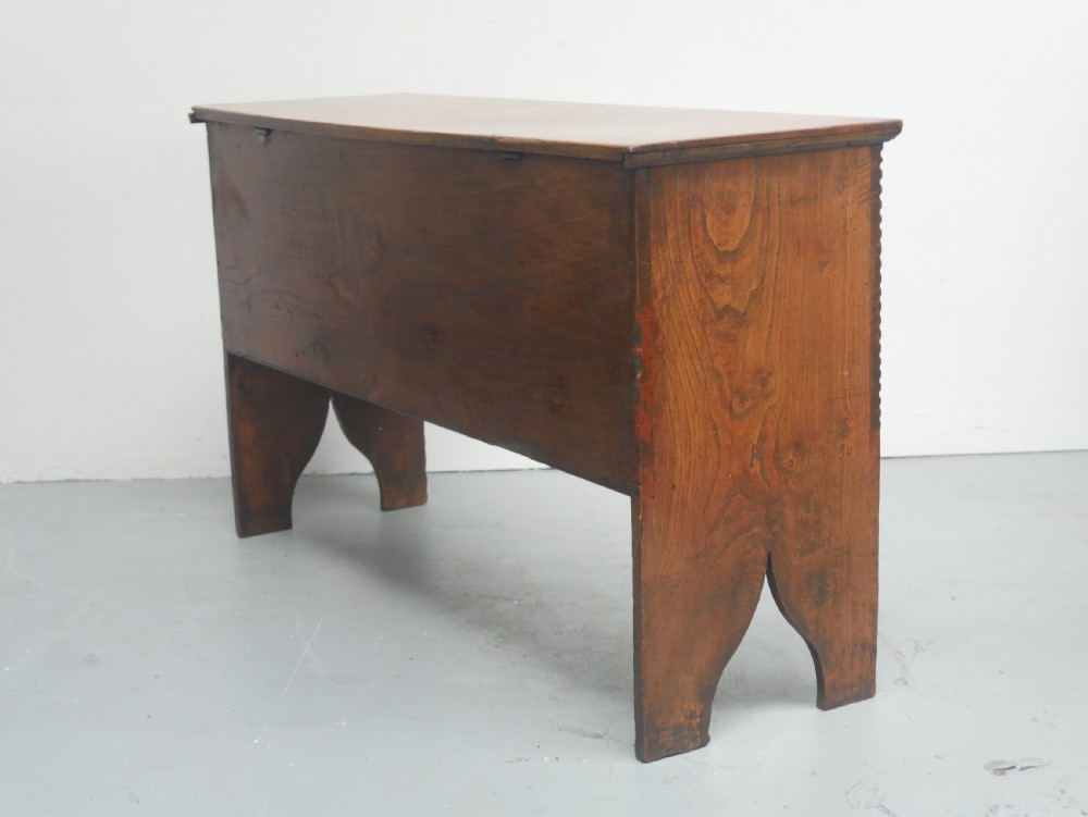 An antique timber six-plank coffer crafted from warm brown elm featuring a central brass keyhole escutcheon and shaped bootjack side panels. View VII