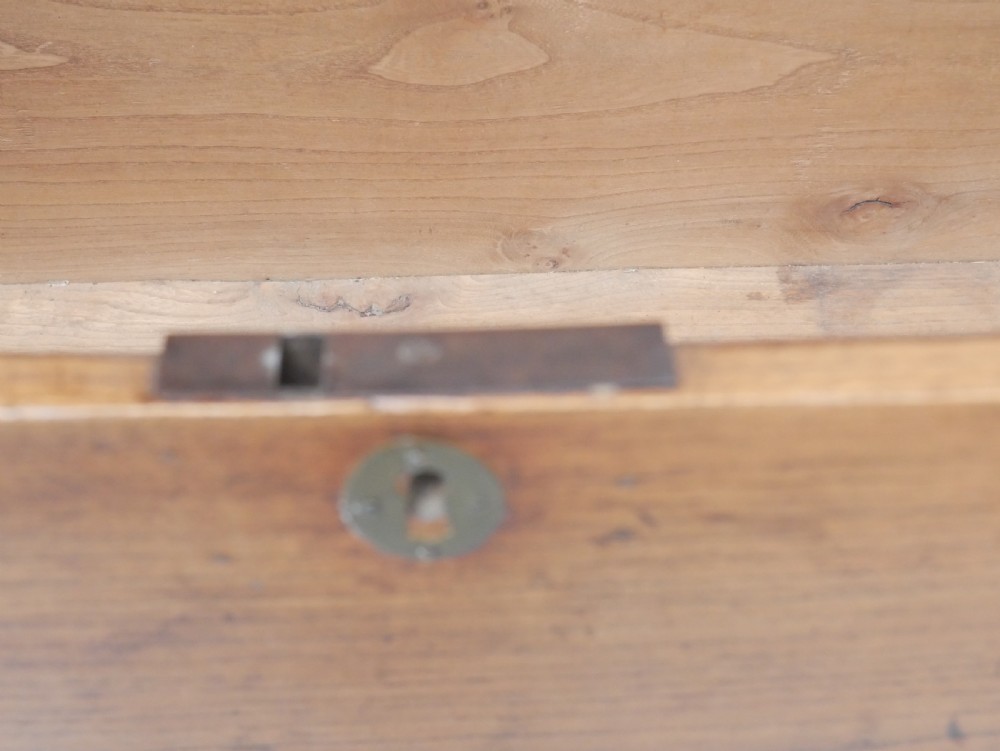 An antique timber six-plank coffer crafted from warm brown elm featuring a central brass keyhole escutcheon and shaped bootjack side panels. View XIV