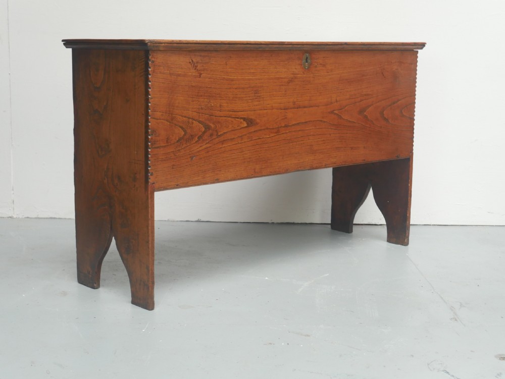 An antique timber six-plank coffer crafted from warm brown elm featuring a central brass keyhole escutcheon and shaped bootjack side panels. View XVI