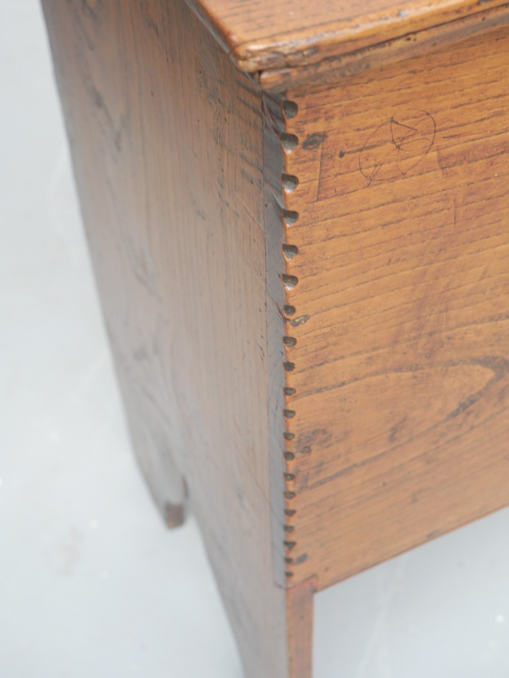 An antique timber six-plank coffer crafted from warm brown elm featuring a central brass keyhole escutcheon and shaped bootjack side panels. View XVIII