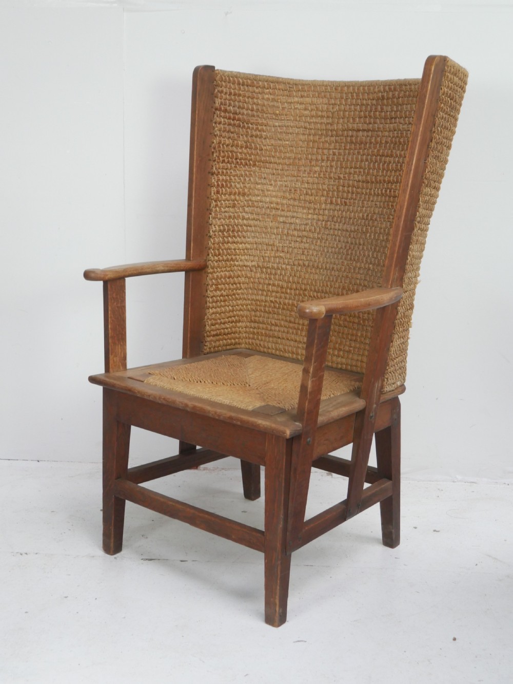 A traditional full-sized Scottish Orkney armchair featuring a timber oak frame, flat wooden armrests, a rush seat, and a tall hand-woven oat straw backrest.
