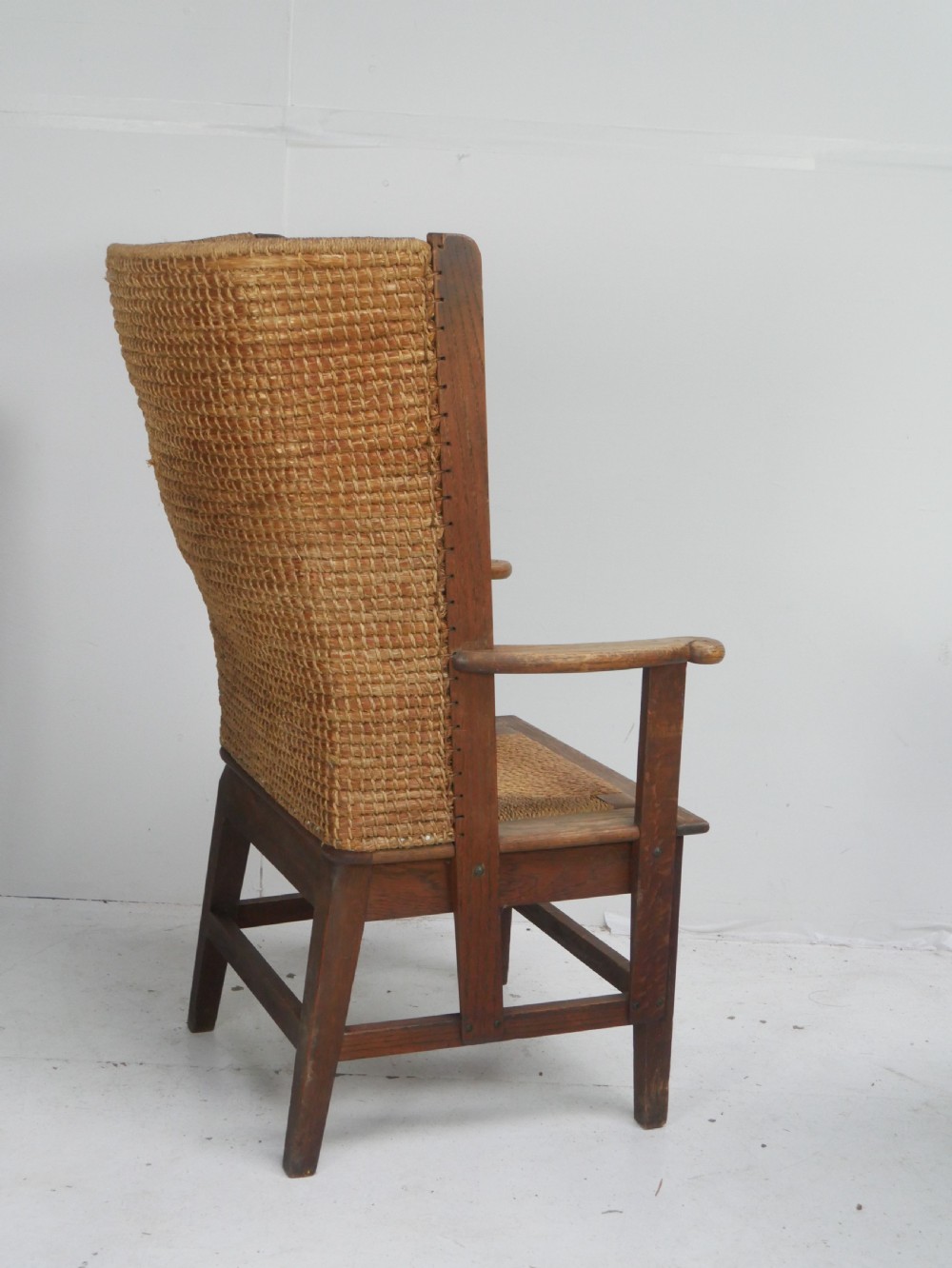 A traditional full-sized Scottish Orkney armchair featuring a timber oak frame, flat wooden armrests, a rush seat, and a tall hand-woven oat straw backrest. View II