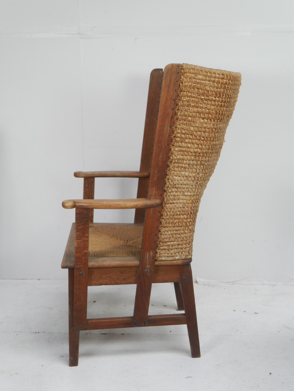 A traditional full-sized Scottish Orkney armchair featuring a timber oak frame, flat wooden armrests, a rush seat, and a tall hand-woven oat straw backrest. View IV
