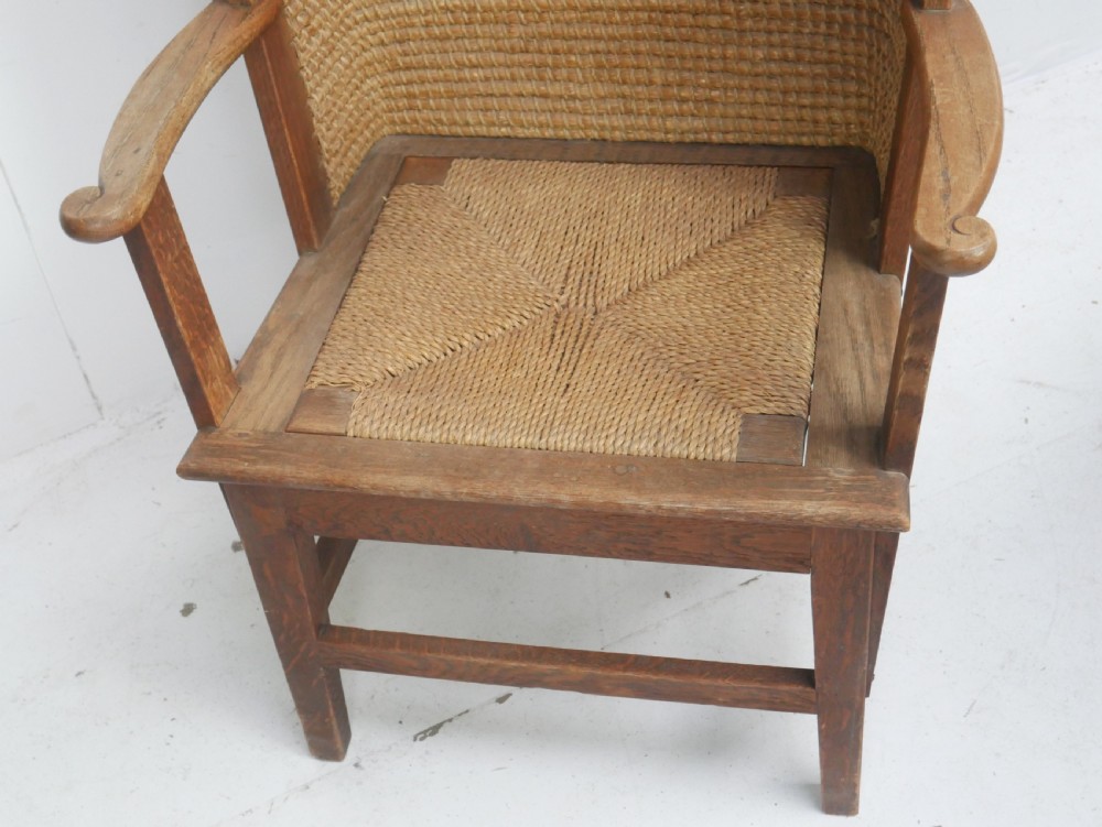 A traditional full-sized Scottish Orkney armchair featuring a timber oak frame, flat wooden armrests, a rush seat, and a tall hand-woven oat straw backrest. View IX