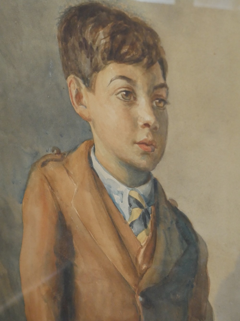 A framed watercolour portrait depicting a young boy standing in full Scottish Highland dress with a brown jacket and tartan kilt. View III