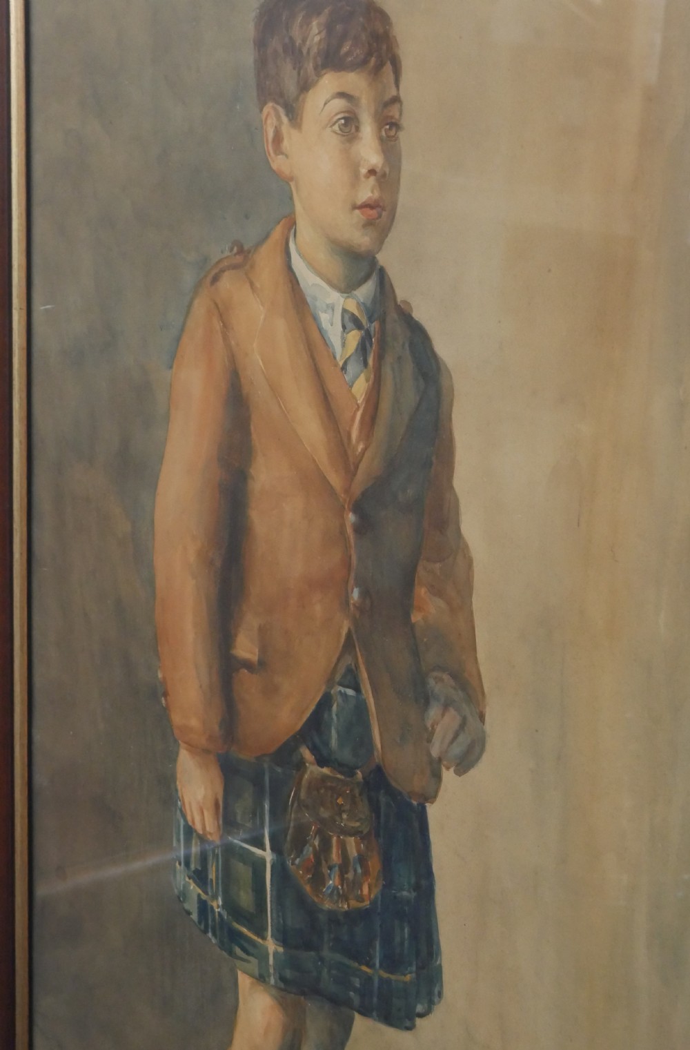 A framed watercolour portrait depicting a young boy standing in full Scottish Highland dress with a brown jacket and tartan kilt. View VI