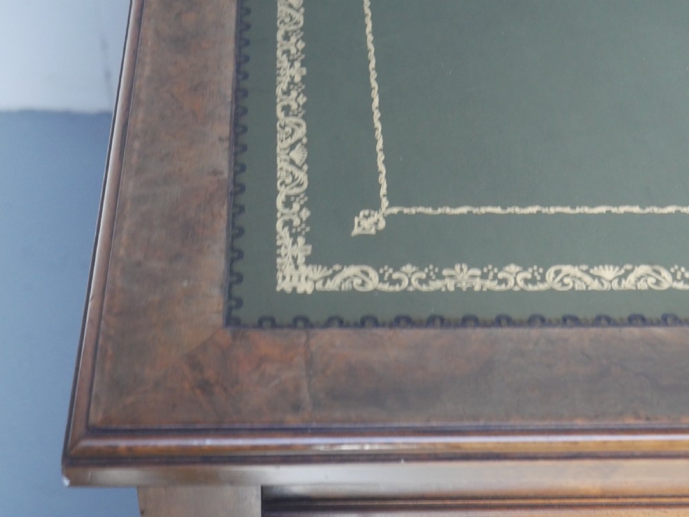 A light walnut writing table featuring a green leather inset top with gilt tooling, a single frieze drawer, and turned fluted legs on brass castors. View VIII