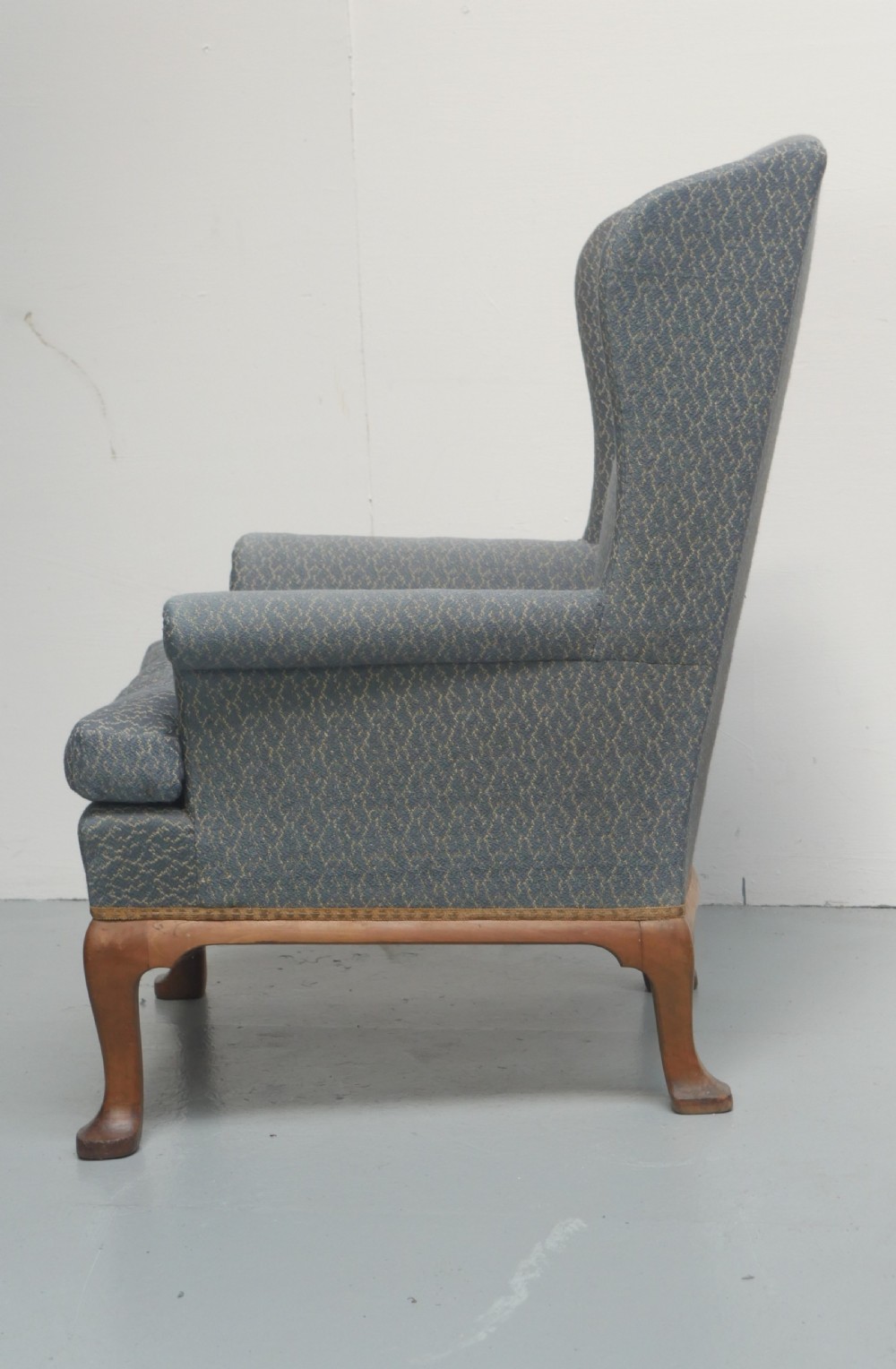 A high-backed wingback armchair upholstered in slate blue patterned fabric, featuring scrolled armrests and wooden cabriole legs. View II