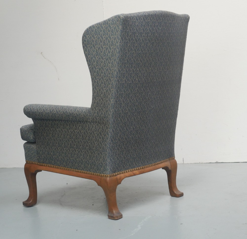 A high-backed wingback armchair upholstered in slate blue patterned fabric, featuring scrolled armrests and wooden cabriole legs. View III