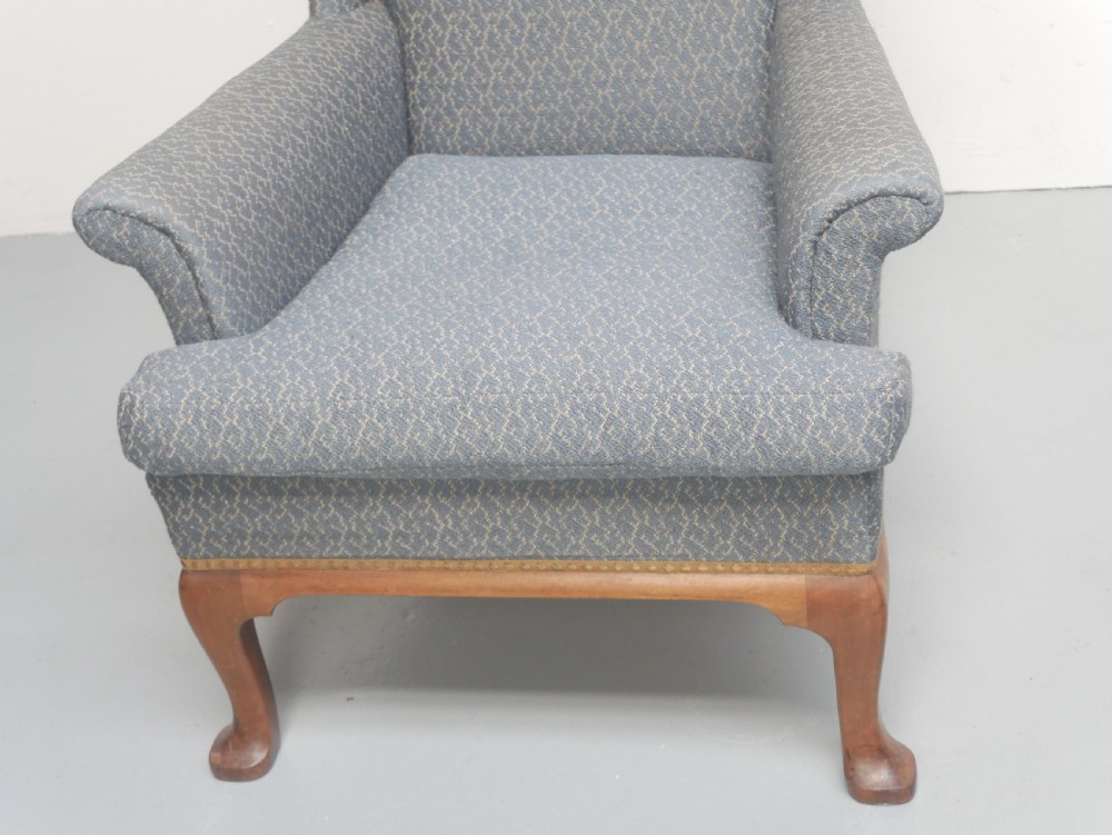 A high-backed wingback armchair upholstered in slate blue patterned fabric, featuring scrolled armrests and wooden cabriole legs. View VIII