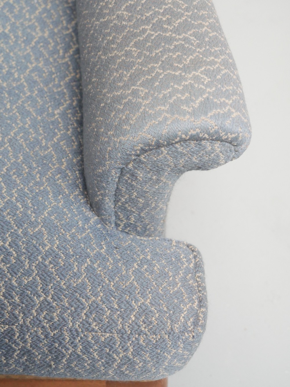A high-backed wingback armchair upholstered in slate blue patterned fabric, featuring scrolled armrests and wooden cabriole legs. View XI
