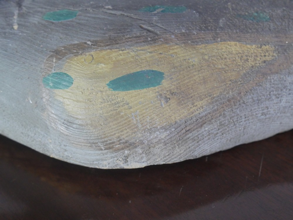 A hand-carved painted wooden decoy duck featuring a dark head and a grey and ochre body. View III
