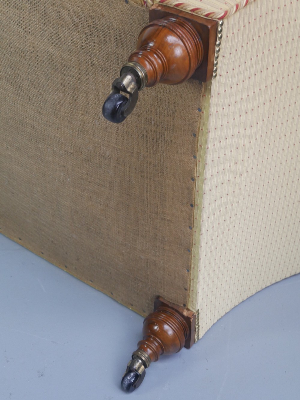 A 19th-century Victorian chaise longue upholstered in a yellow patterned fabric with deep buttoning on the curved backrest and turned mahogany legs on brass castors. View III