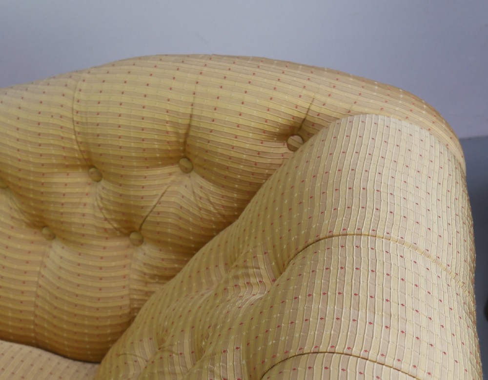 A 19th-century Victorian chaise longue upholstered in a yellow patterned fabric with deep buttoning on the curved backrest and turned mahogany legs on brass castors. View IX