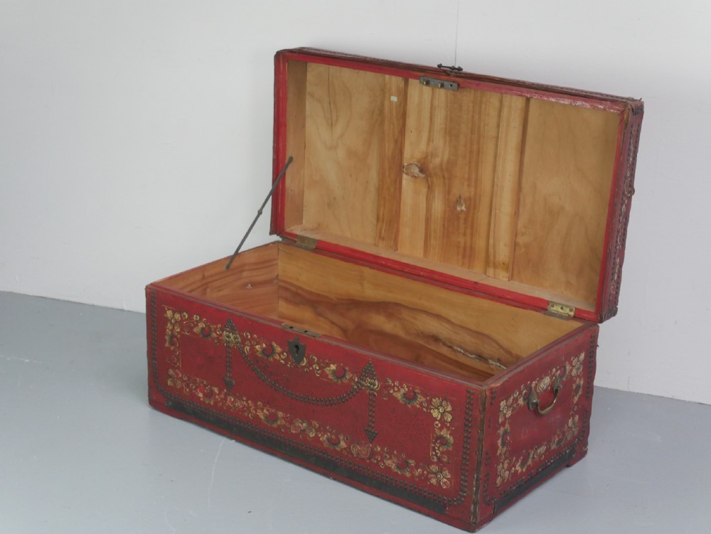 A rectangular red leather China trade trunk decorated with brass studs, brass side handles, and hand-painted gold floral motifs. View III